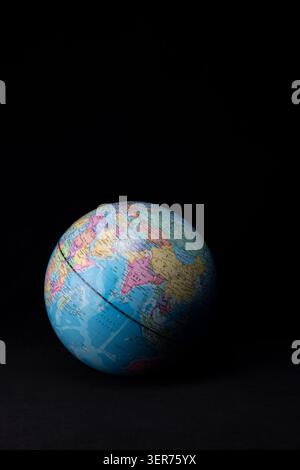 Globe displaying continents and oceans on black background Stock Photo