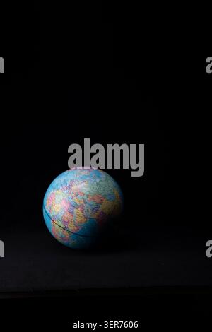 Planet earth model displaying global map on a dark background Stock Photo