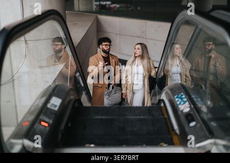 Business colleagues discussing plans while riding an escalator in an urban building Stock Photo