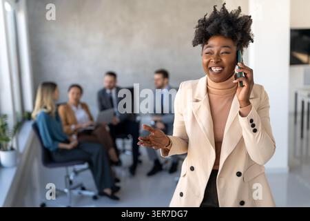 Young happy successful business woman working in corporate office Stock Photo