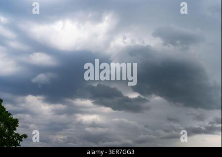 Dense gray and white cumulus clouds filling the vast overcast sky before a storm. Stock Photo