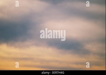 Soft pastel clouds creating a subtle color gradient across the evening sky. Stock Photo