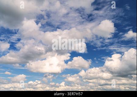 Vibrant blue sky with various fluffy white and grey cloud formations during daytime. Stock Photo