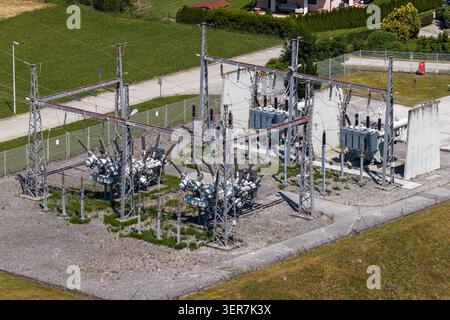 This aerial view shows an electrical substation with power transformers and high voltage gear that support electricity distribution. Stock Photo
