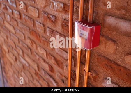 Utility box with copper pipes on a brick wall in a building Stock Photo