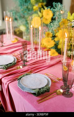 Elegant Spring Table Setting with Pink Tablecloth and Yellow Flowers Stock Photo