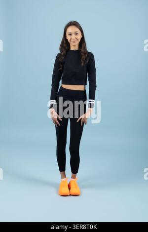 Confident young woman standing straight in fitness pose ready for workout Stock Photo