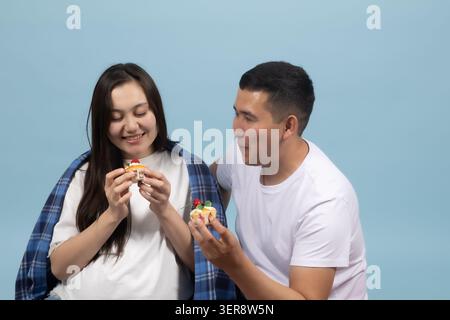 Loving young beautiful couple gently feeding each other with delicious food Stock Photo