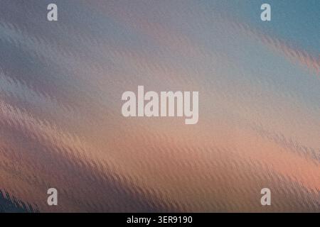An artistic abstract background featuring diagonal, wavy, textured stripes with a soft gradient blending blue, grey, and warm peach tones. Stock Photo