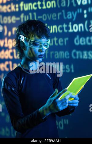 Futuristic cyberpunk young woman wearing VR glasses studies a glowing tablet as lines of code fill the background, evoking virtual reality, hacking, A Stock Photo