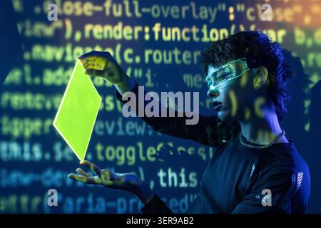 Futuristic cyberpunk young woman wears augmented reality visor and interacts with glowing hologram panel, with projected code background, exploring vi Stock Photo