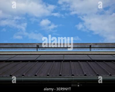 heavily soiled photovoltaic panels on industrial hall roof highlighting importance of regular solar maintenance cleaning Stock Photo