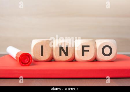 Wooden cubes with INFO text on a red notebook. Stock Photo