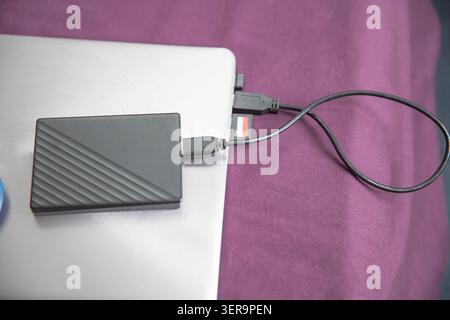 External portable hard drive connected to laptop for secure data backup storage Stock Photo