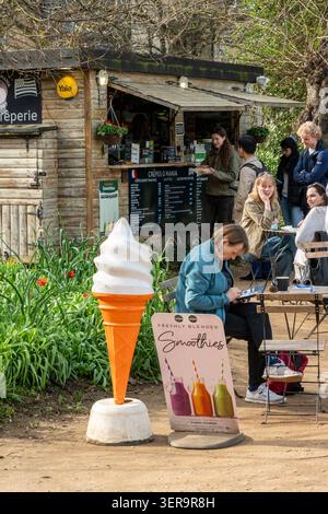 Customers at a small outside cafe in Oxford city centre with a large advertising ice cream cone in the foreground. Stock Photo