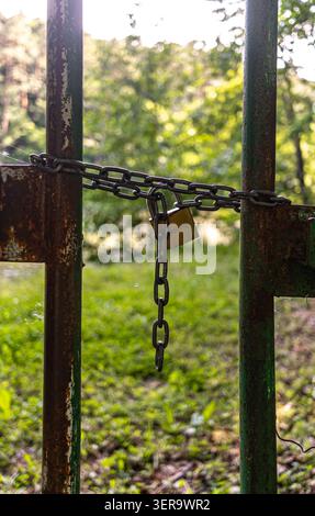 A padlock with a chain on an old iron gate Stock Photo
