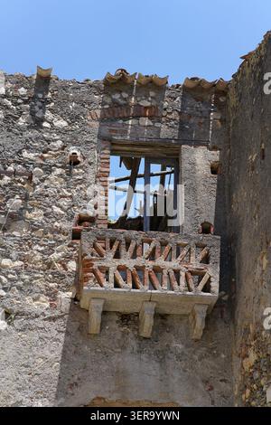 Decaying stone building with small balcony and broken window in the historic village of Palizzi, Aspromonte National Park, Calabria Southern Italy. Stock Photo