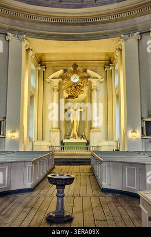 Karlskrona, Sweden - 14 September 2025: View of the interior of the Church of the Holy Trinity featuring the altar with a golden cross, wooden pews, a Stock Photo
