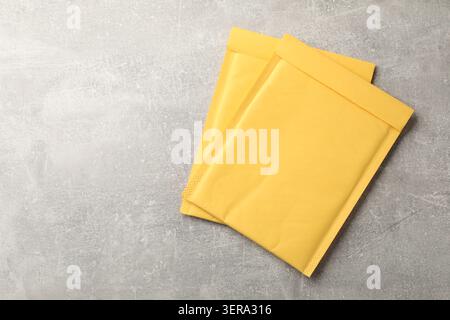 Stack of yellow envelopes on grey table, top view. Space for text Stock Photo