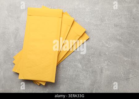 Stack of yellow envelopes on grey table, top view. Space for text Stock Photo