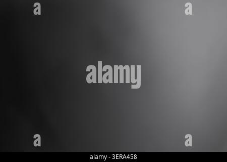 Smooth gradient background transitions from dark gray on the left to light gray on the right. Minimalist design suitable for various applications. Stock Photo
