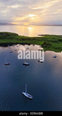 A peaceful aerial view over Oban Bay, where sailboats rest on calm waters beneath the dramatic skies of Scotland's west coast Stock Photo