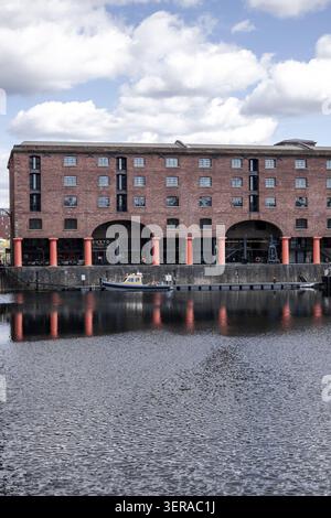Liverpool, United Kingdom - 06 May 2026: View of the historic red brick warehouses at Royal Albert Dock with orange columns reflecting in the water un Stock Photo