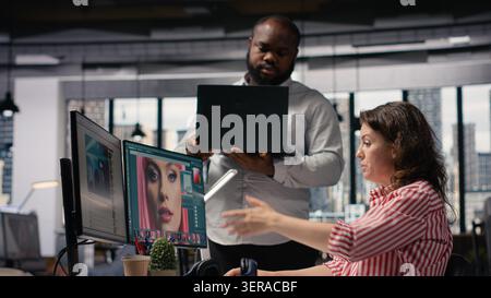 Creative designers team working on image editing and retouching with software on PC, color correction for editorial post production in agency office. Artistic tasks for catalog materials. Stock Photo