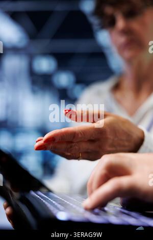 Colleagues performing diagnostic assessments on mainframes to detect problems with server room units. Coworkers crosschecking maintenance lists, looking for potential system concerns, close-up. Stock Photo