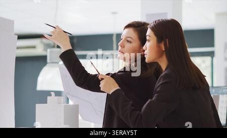 Design group interprets dimensions working in real estate brokerage headquarters, planners team create schematics and patterns for constructors, contributing to production stage. Stock Photo