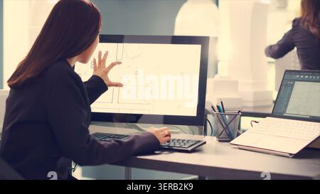 Architect designing blueprints for house remodeling project, using modern CAD software on computer to create new floor plan for customers, engineer takes measurements on layout sketches in office. Stock Photo