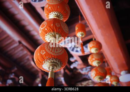 Traditional Red Chinese Lanterns Hanging from Temple Ceiling, Low Angle View Stock Photo