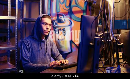 Hacker group coordinating DDoS attack on website, working on multiple computers to sending large amounts of traffic and overwhelm it, rogue programmers in secret bunker flooding target server. Stock Photo