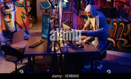 Hackers discussing plan on how to use network vulnerabilities to exploit servers, trying to break computer systems at night. Stock Photo