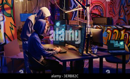 Hackers in hidden base excited after successfully getting past anti tamper measures implemented by companies to protect their products, crackers happy after pirating software and video game releases. Stock Photo