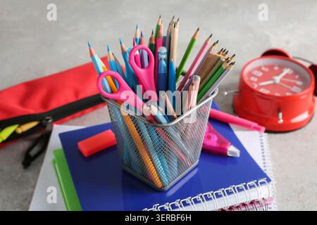 Pencil holder and notebooks on grey background Stock Photo