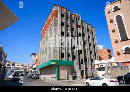 Unfinished building construction site showing concrete pillars with grey breeze blocks and red bricks walls in Taif, Saudi Arabia Stock Photo