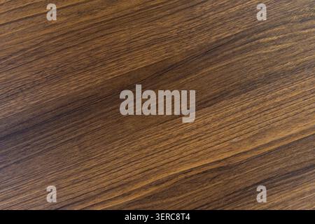 A close-up texture shot of dark brown natural wood grain with a diagonal composition, showing the rich surface detail of hardwood flooring or furniture material. Stock Photo