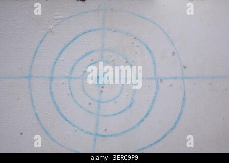 Close-up of a target pattern printed on a foam board with multiple impact marks and holes. Concept image related to target practice. Stock Photo
