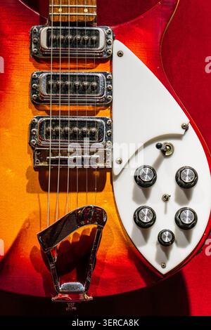 Vintage electric guitar featuring multi-toned finish, warm colors, visible wood grain, white headstock, six tuning pegs, dual pickup configuration, bo Stock Photo