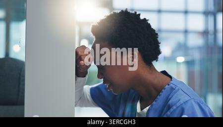 Medical, nurse and sad with stress in clinic for grieving loss, operation failure and shift trauma. Health professional, black woman or unhappy in Stock Photo