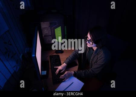 High Angle View of Woman Typing on Keyboard at Night Stock Photo