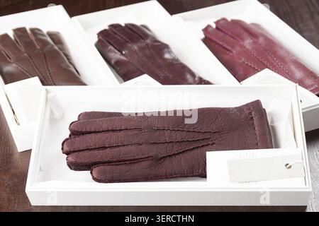 Burgundy leather gloves in boxes at luxury clothing boutique store Stock Photo