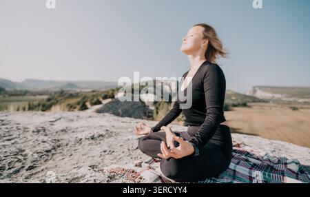 Woman Meditating on a Mountaintop Stock Photo