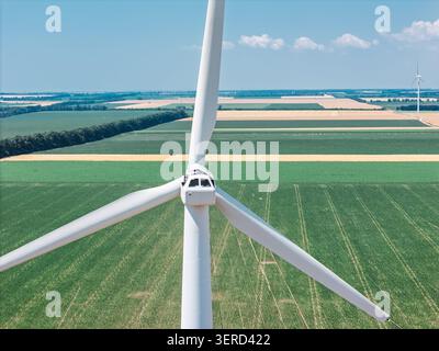 Professional engineer servicing wind power generator in field. Aerial Stock Photo