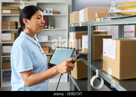 Hispanic Woman Scanning Packages for Order Fulfillment Stock Photo