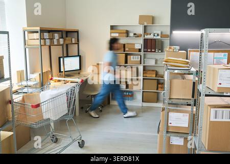 Woman Working at Order Pickup Point and Packing Deliveries Stock Photo