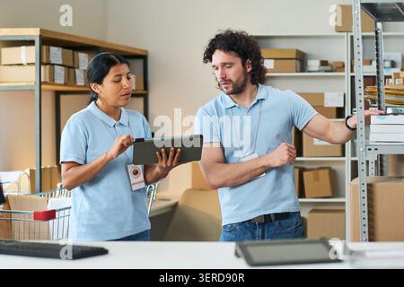 Delivery Workers Checking Orders at Pickup Point for Fulfillment Stock Photo