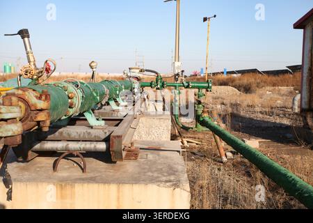 A close-up shot of the green anti-corrosion oil pipeline system at the oilfield wellhead on an autumn autumn. Pipes, valves, flanges and fasteners are Stock Photo