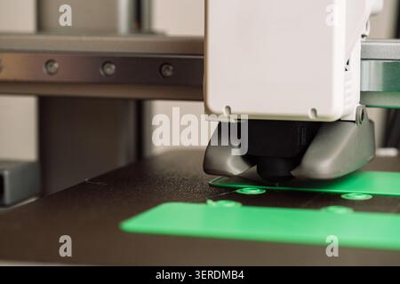 3D printer printing green plastic parts on build plate, close-up of additive manufacturing process Stock Photo